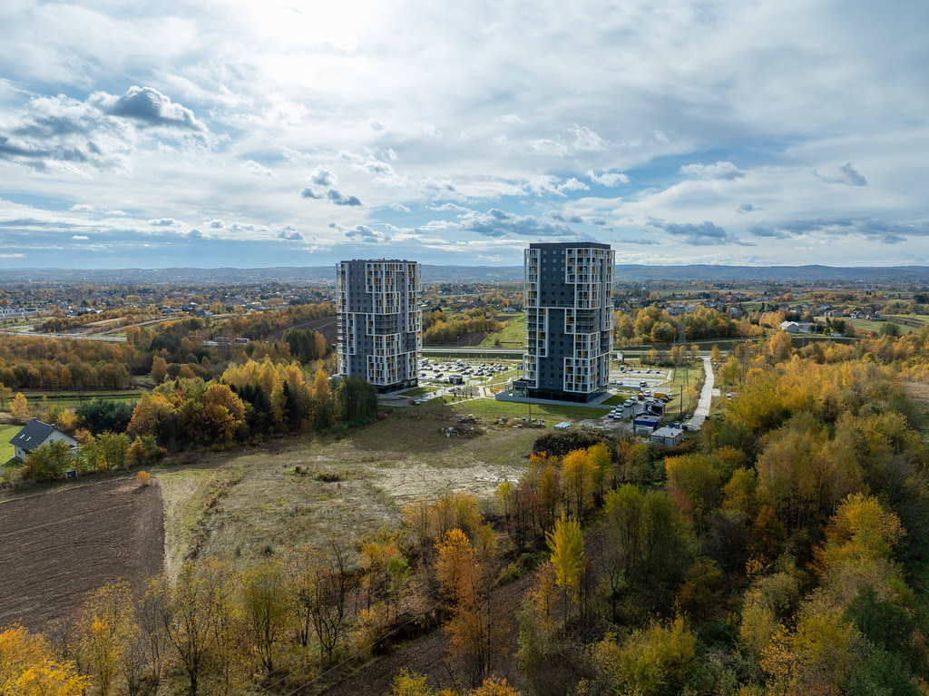 Ujęcie z drona nad terenem inwestycji – dwa wysokie zbiorniki i jesienny krajobraz