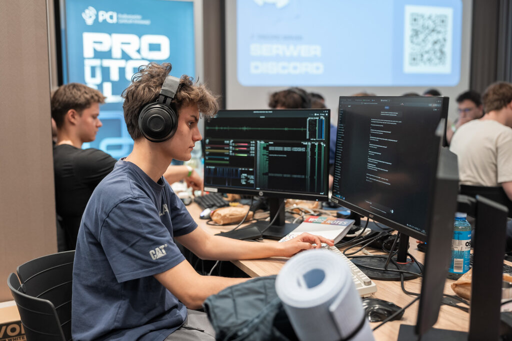 Uczestnik hackathonu kodujący w słuchawkach